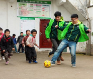 来自上海的志愿者和孩子一起踢球